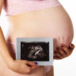 Babybauch und Ultraschallbild - ein solches Foto zu machen, wünschen sich viele Paare, die trotz fleißigem 'Üben' nicht schwanger werden. Kinderwunschzentren im Inland und Ausland versuchen mit verschiedenen Verfahren wie IVF, Eizellenspende, ICSI, PICSI, verlängerter Kultivierung, Assisted Hatching u.a. eine Schwangerschaft trotz aller Schwierigkeiten herbeizuführen (© Frank Eckgold / Fotolia)