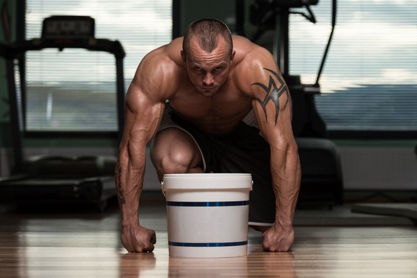 Kraftsportler mit Nahrungsergänzungsmittel / Supplement-Eimer (© Jasminko Ibrakovic - Fotolia.com)