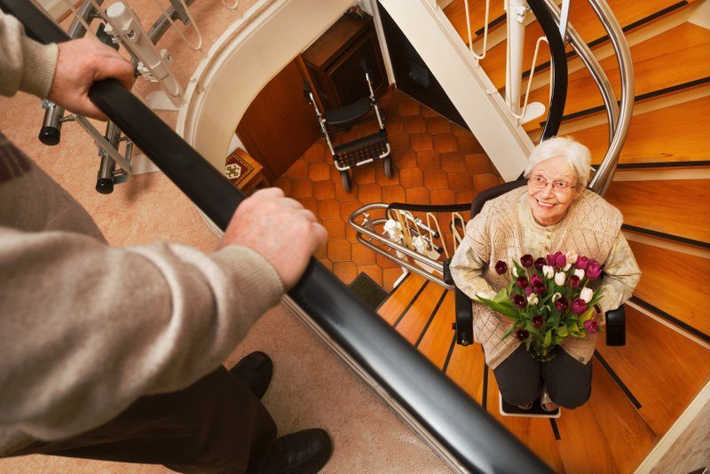 Ein Treppenlift für eine Wendeltreppe ist zwar aufwändiger im Einbau und damit von den Kosten auch teurer; aber Preise hin oder her: das Lächeln dieser Oma zeigt, wie viel (Rückgewinn an) Lebensqualität es bedeutet, mobil trotz der vorhandenen Einschränkungen zu sein (© Ingo Bartussek / Fotolia)